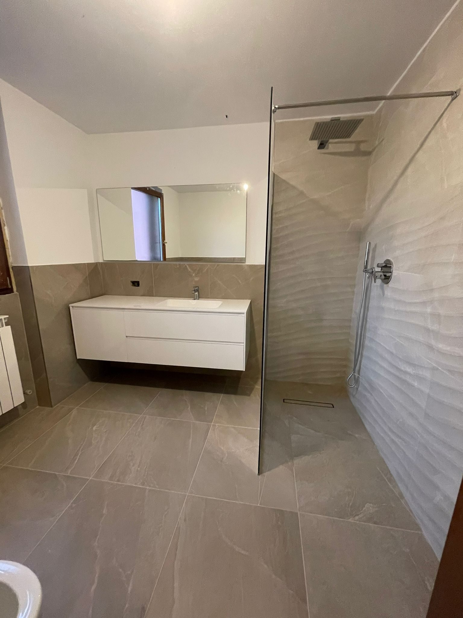 Bagno completo con doccia in cristallo e mobile lavabo su misura