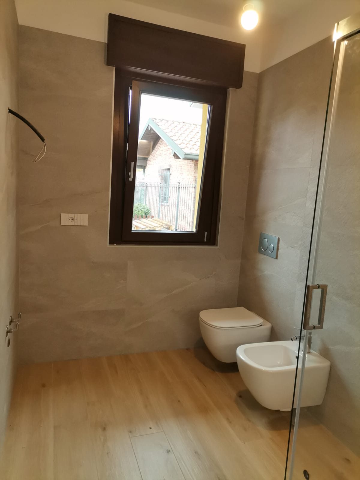 Bagno ultimato con rivestimento in gres effetto pietra e sanitari sospesi