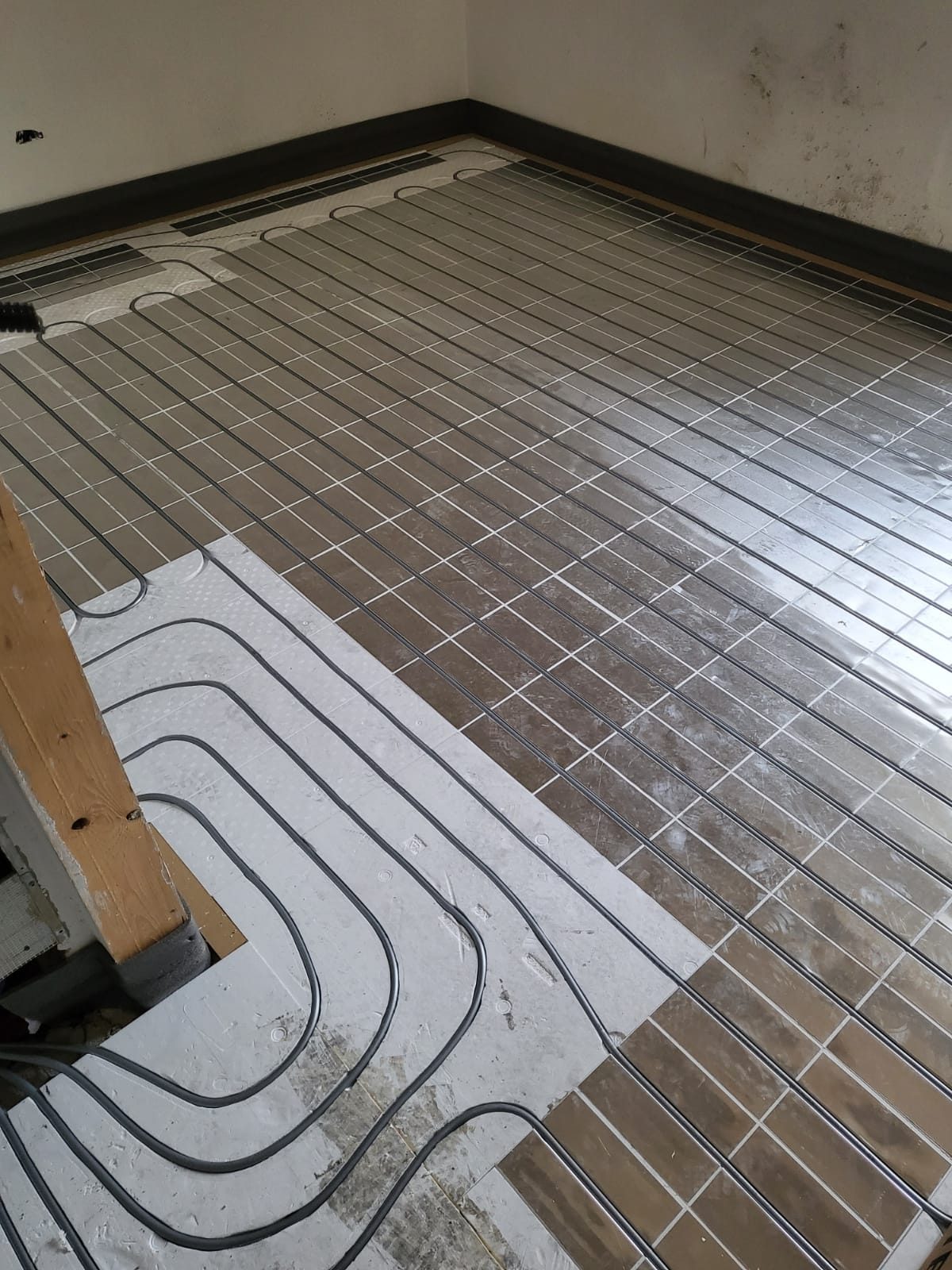 Serpentine di tubo per riscaldamento a pavimento posate su pannelli isolanti in cantiere